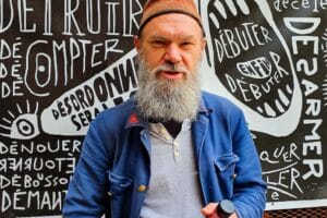 Photo de Timotéo Sergoï devant l'une de ses oeuvres