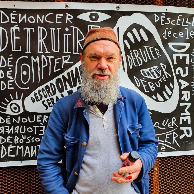 Photo de Timotéo Sergoï devant l'une de ses oeuvres