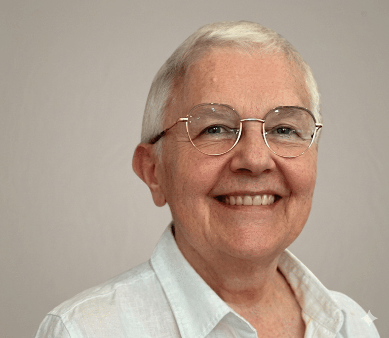 Portrait de Françoise Lempereur souriant devant un mur blanc