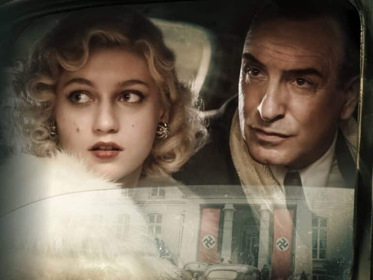 Deux acteurs dans une voiture regardant par la fenêtre de la portière