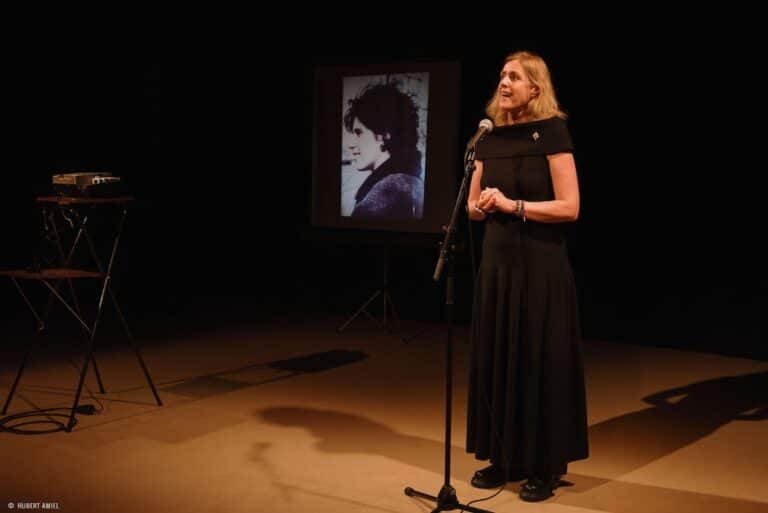 L'artiste Geneviève Damas sur une scène derrière un micro