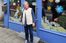 Monica Nève devant la vitrine d'une boutique