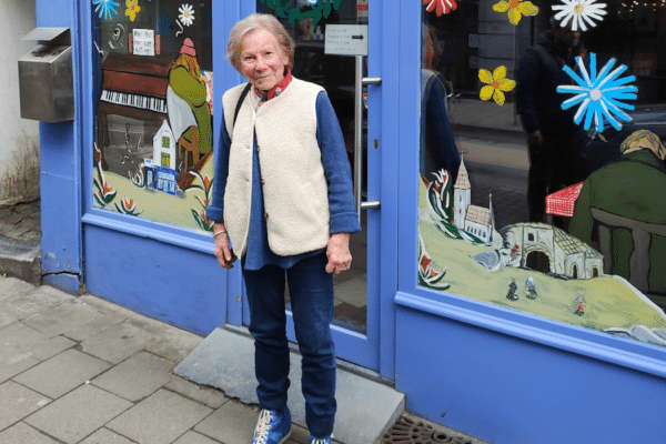 Monica Nève devant la vitrine d'une boutique