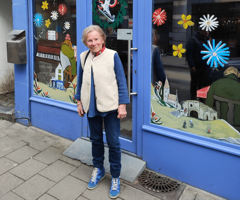 Monica Nève devant la vitrine d'une boutique