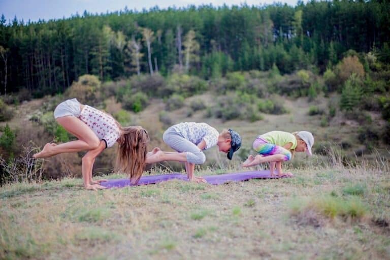 Des personnes faisant du yoga sur un tapis dont deux enfants